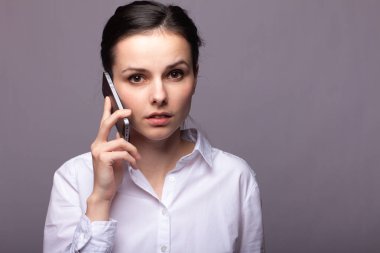 beyaz gömlekli kız telefonda iletişim kuruyor