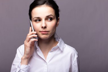beyaz gömlekli kız telefonda iletişim kuruyor