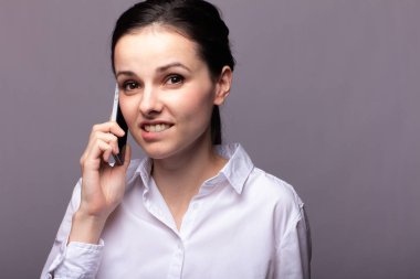 beyaz gömlekli kız telefonda iletişim kuruyor