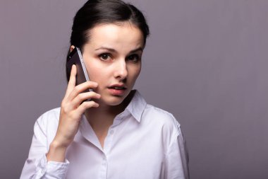 beyaz gömlekli kız telefonda iletişim kuruyor