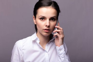 beyaz gömlekli kız telefonda iletişim kuruyor