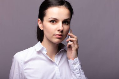 beyaz gömlekli kız telefonda iletişim kuruyor