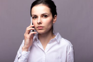 beyaz gömlekli kız telefonda iletişim kuruyor