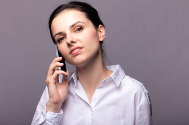 beyaz gömlekli kız telefonda iletişim kuruyor
