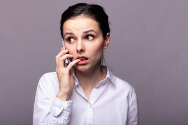 beyaz gömlekli kız telefonda iletişim kuruyor