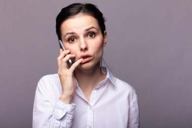 beyaz gömlekli kız telefonda iletişim kuruyor