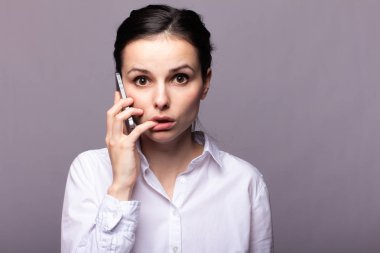 beyaz gömlekli kız telefonda iletişim kuruyor