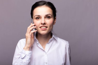 beyaz gömlekli kız telefonda iletişim kuruyor