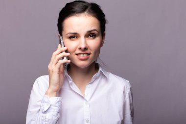 beyaz gömlekli kız telefonda iletişim kuruyor