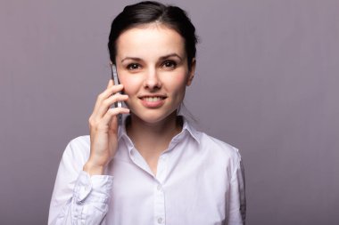 beyaz gömlekli kız telefonda iletişim kuruyor