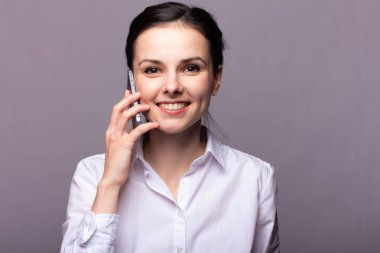 beyaz gömlekli kız telefonda iletişim kuruyor