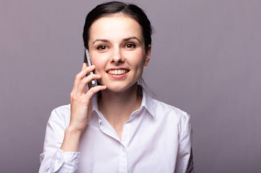 beyaz gömlekli kız telefonda iletişim kuruyor