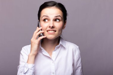 beyaz gömlekli kız telefonda iletişim kuruyor