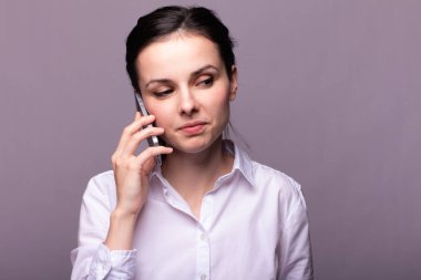 beyaz gömlekli kız telefonda iletişim kuruyor