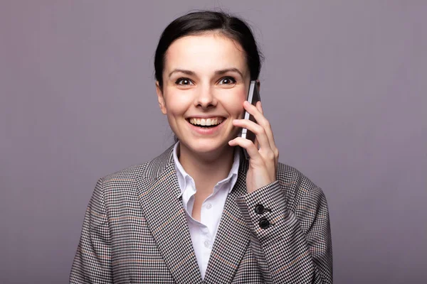 Beyaz gömlekli güzel bir genç kız, telefonda bir ceket konuşuyor.