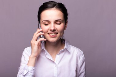 beyaz gömlekli kız telefonda iletişim kuruyor