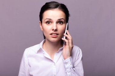 beyaz gömlekli kız telefonda iletişim kuruyor