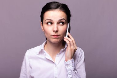 beyaz gömlekli kız telefonda iletişim kuruyor