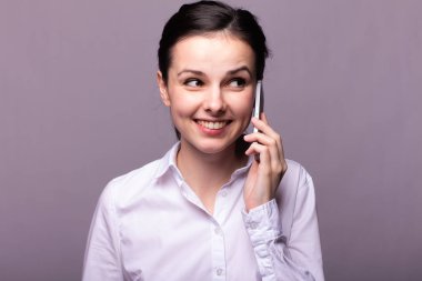 beyaz gömlekli kız telefonda iletişim kuruyor