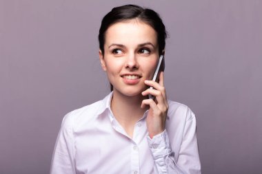 beyaz gömlekli kız telefonda iletişim kuruyor