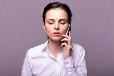 beyaz gömlekli kız telefonda iletişim kuruyor