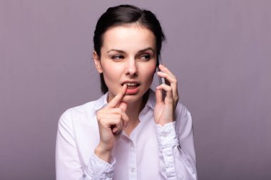 beyaz gömlekli kız telefonda iletişim kuruyor