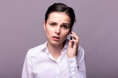 beyaz gömlekli kız telefonda iletişim kuruyor