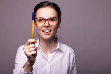 beyaz gömlek ve gözlük kız elinde bir kalem tutar