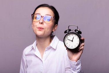 beyaz gömlek ve gözlük kız elinde bir çalar saat tutar