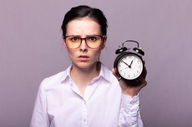 beyaz gömlek ve gözlük kız elinde bir çalar saat tutar