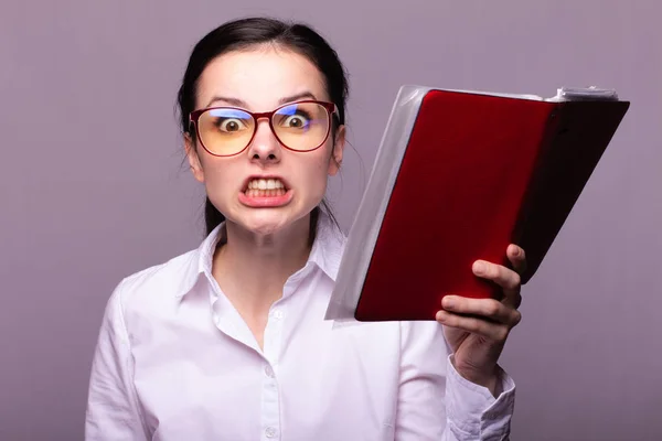 beyaz gömlek ve gözlük kız elinde kırmızı bir defter tutar