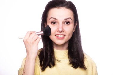 Çekici kız makyaj yapıyor, makyaj fırçası yapıyor.