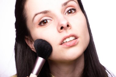 Çekici kız makyaj yapıyor, makyaj fırçası yapıyor.