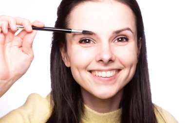 Güzel genç kız kaşlarını boyuyor.