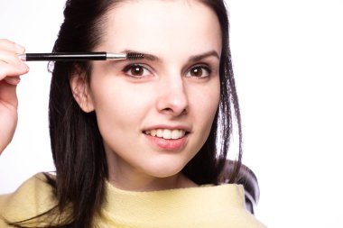 Güzel genç kız kaşlarını boyuyor.