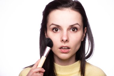 Çekici kız makyaj yapıyor, makyaj fırçası yapıyor.