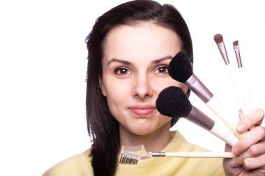 Çekici kız makyaj yapıyor, makyaj fırçası yapıyor.