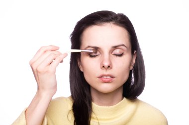 Çekici kız makyaj yapıyor, makyaj fırçası yapıyor.