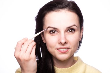 Çekici kız makyaj yapıyor, makyaj fırçası yapıyor.