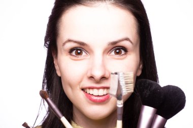 Çekici kız makyaj yapıyor, makyaj fırçası yapıyor.