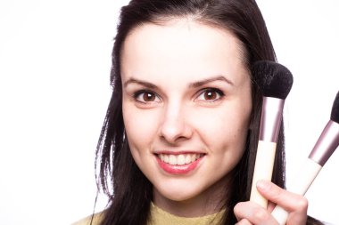 Çekici kız makyaj yapıyor, makyaj fırçası yapıyor.