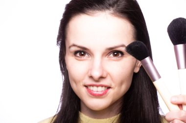 Çekici kız makyaj yapıyor, makyaj fırçası yapıyor.