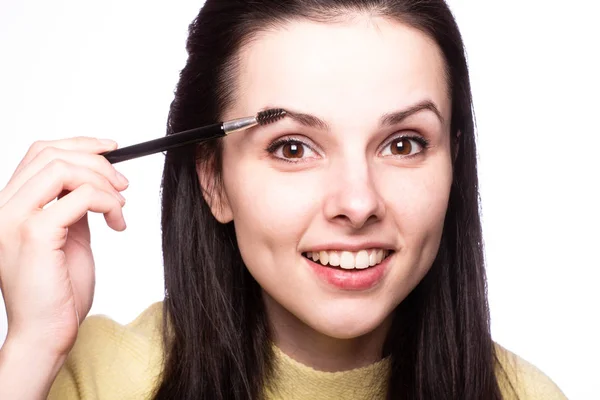 beautiful young girl paints eyebrows