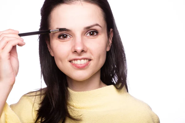 beautiful young girl paints eyebrows