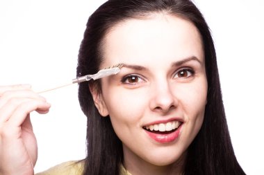 Güzel genç kız kaşlarını boyuyor.