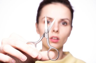 Güzel genç kız manikür makasını elinde tutuyor.