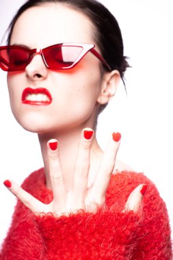 Kırmızı güneş gözlüklü genç kadın, kırmızı ruj, kırmızı kazak.