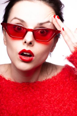 Kırmızı güneş gözlüklü genç kadın, kırmızı ruj, kırmızı kazak.