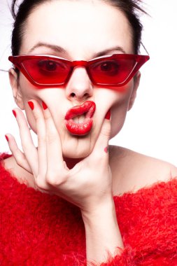 Kırmızı güneş gözlüklü genç kadın, kırmızı ruj, kırmızı kazak.