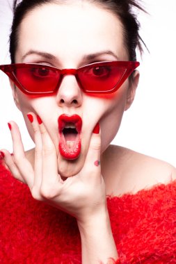 Kırmızı güneş gözlüklü genç kadın, kırmızı ruj, kırmızı kazak.